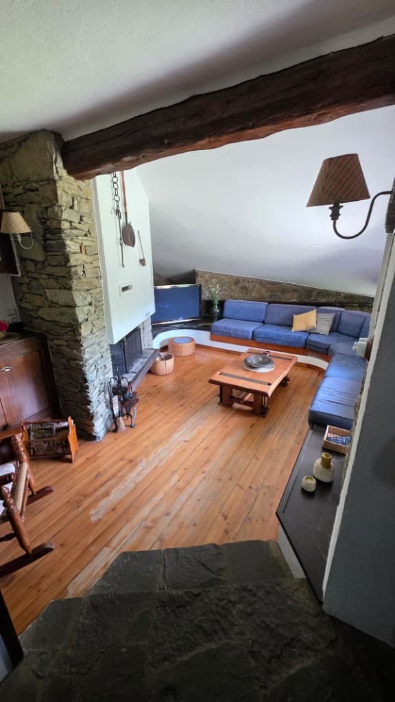 Living room with stone walls, beams and blue sofa